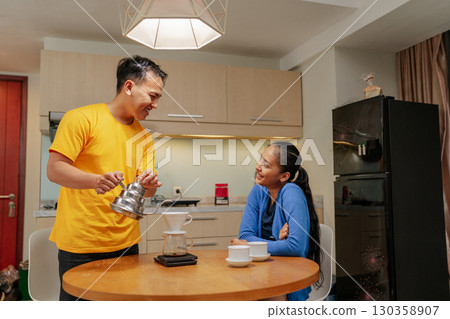 Warm Moments A Couple Enjoys Sipping Coffee Together in a Beautiful Modern Kitchen 130358907