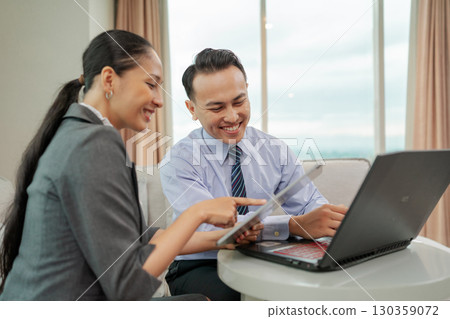 Engaging in a Collaborative Business Meeting While Using Laptop in a Modern Office Space 130359072