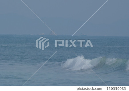 海浪拍打著湘南，遠處是朦朧的烏帽岩，還有漁船 130359083