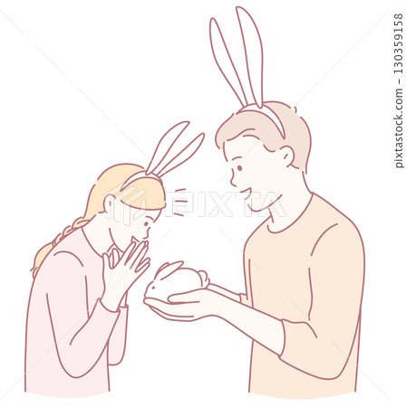 A couple wearing bunny ears is joyfully admiring a cute rabbit with great affection and delight 130359158