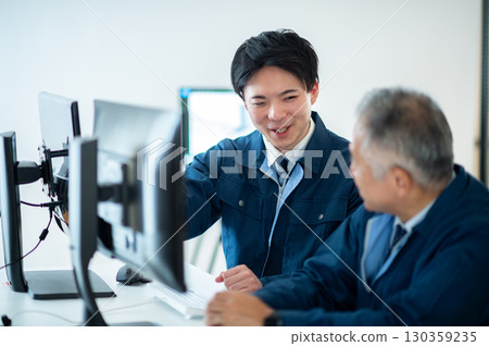 A veteran and a young employee conversing in the office A veteran and a young employee conversing in the office 130359235