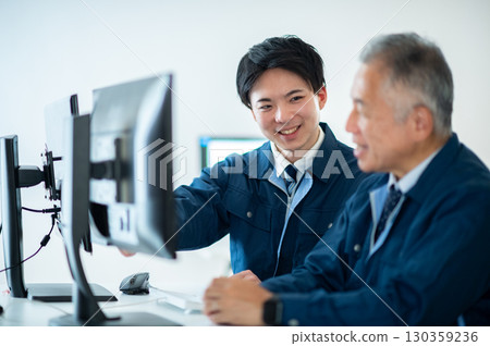 一位老員工和一位年輕員工在辦公室交談 130359236