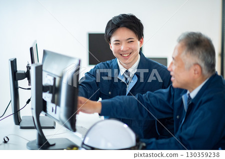 A veteran and a young employee conversing in the office A veteran and a young employee conversing in the office 130359238