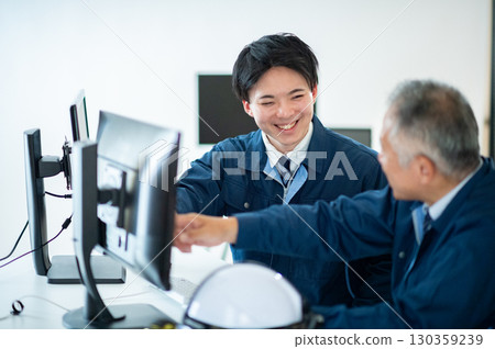 A veteran and a young employee conversing in the office 130359239