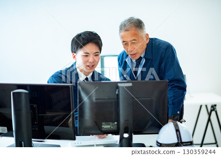 A veteran and a young employee conversing in the office 130359244