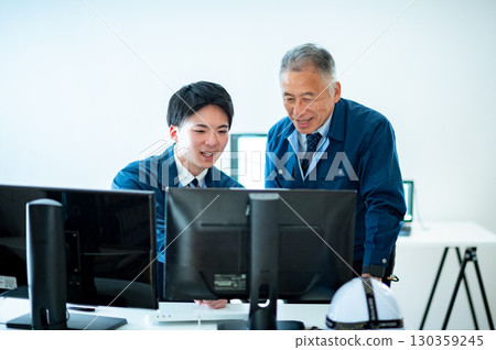 A veteran and a young employee conversing in the office 130359245
