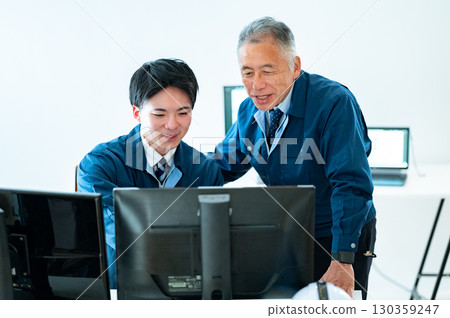 A veteran and a young employee conversing in the office 130359247