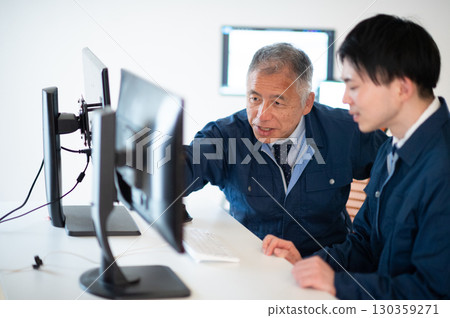 A veteran and a young employee conversing in the office 130359271