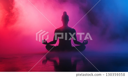 A serene silhouette sits in meditation surrounded by vibrant hues of blue and pink. The tranquil atmosphere invites moments of reflection and mindfulness. Generative AI 130359358