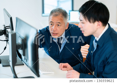 A veteran and a young employee conversing in the office A veteran and a young employee conversing in the office 130359621
