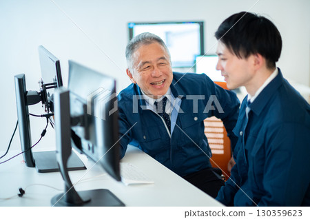 一位老員工和一位年輕員工在辦公室交談 130359623
