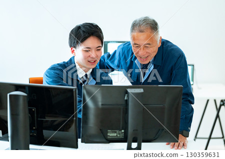 A veteran and a young employee conversing in the office 130359631