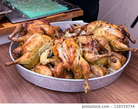 Large tray filled with roasted chickens ready for serving. Traditional cuisine, culinary preparation and gastronomy. Large tray filled with roasted chickens ready for serving. Traditional cuisine, culinary preparation and gastronomy. 130359734