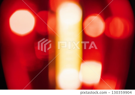 Abstract image showing blurred red light with bokeh spheres against a dark background, creating a dreamy and atmospheric effect. Decorative element suitable for use as a background 130359904