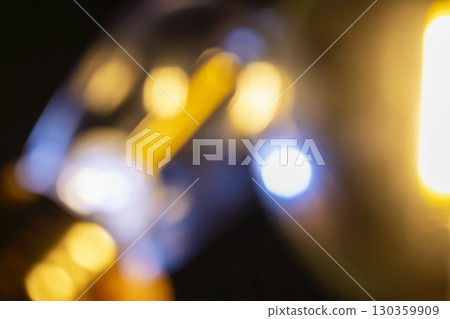 Abstract image showing blurred golden light with bokeh spheres against a dark background, creating a dreamy and atmospheric effect. Decorative element suitable for use as a background Abstract image showing blurred golden light with bokeh spheres against a dark background, creating a dreamy and atmospheric effect. Decorative element suitable for use as a background 130359909