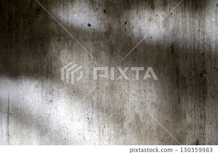 Abstract image of a grungy and aged cement surface. The texture features cracks and a shadow overlay. Copy space. Textured background 130359983