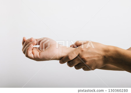 An Asian man's sad portrait, dealing with wrist pain, likely related to carpal tunnel syndrome. Studio shot isolated on white, focusing on health care and medical awareness. 130360280