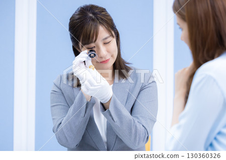 一位女士在採購公司的櫃檯評估一件商品 130360326