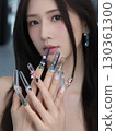 Portrait of a woman showing jeweled nails 130361300