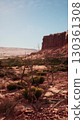 A view of a desert area in Nevada featuring a prominent rock formation in the background under the clear sky. 130361308