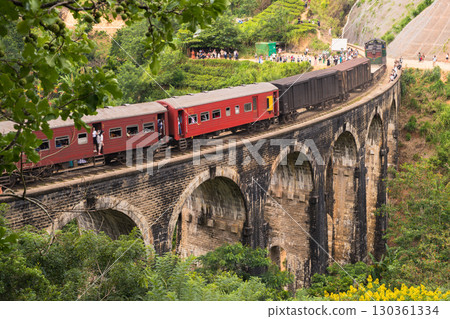 Sri Lanka train on Nine Arch Bridge. Tourists watch. Ella Sri Lanka train on Nine Arch Bridge. Tourists watch. Ella 130361334