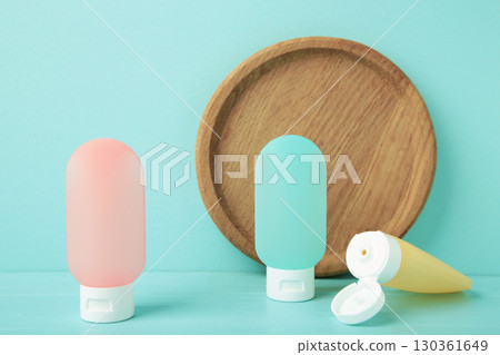 Travel bottles with body care cosmetics on blue background Travel bottles with body care cosmetics on blue background 130361649