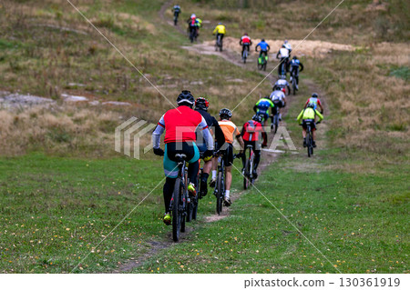 Group cyclists riding uphill behind each other at mountain bike competition 130361919