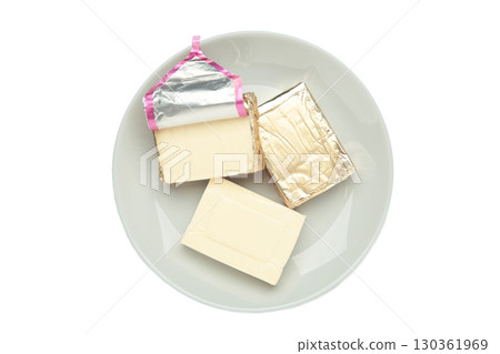 Processed cheese in foil on grey plate isolated on white background 130361969