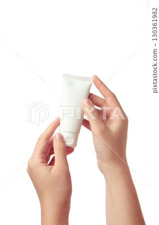 Hand holding blank white plastic tube isolated on white background. 130361982