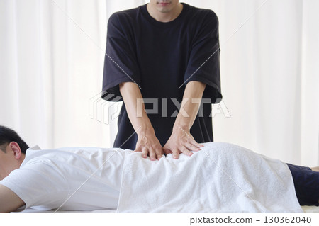 Masseuse massaging the lower back (no face) 130362040
