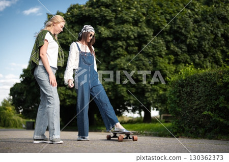 Friends enjoying a sunny afternoon while skateboarding in the park Friends enjoying a sunny afternoon while skateboarding in the park 130362373