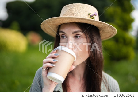 Enjoying a warm beverage in a serene garden setting on a sunny day 130362505