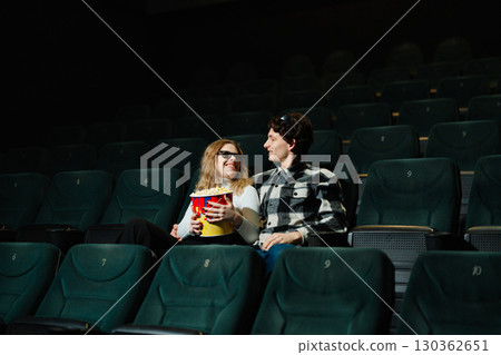Couple enjoys a movie date night in an empty theater setting 130362651