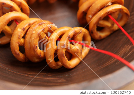 Pretzel cookies tied with red string in wooden bowl Pretzel cookies tied with red string in wooden bowl 130362740