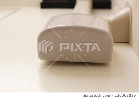 Wall-mounted drain pump for air conditioner with water droplets underneath, indicating malfunction or leakage. 130362859