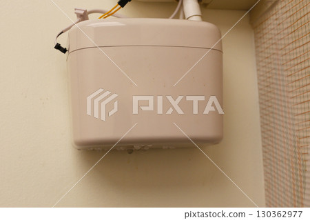Wall-mounted drain pump for air conditioner with water droplets underneath, indicating malfunction or leakage. 130362977