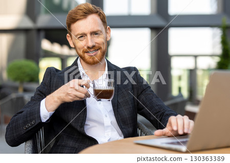 Caucasian professional checking emails on laptop with coffee Caucasian professional checking emails on laptop with coffee 130363389