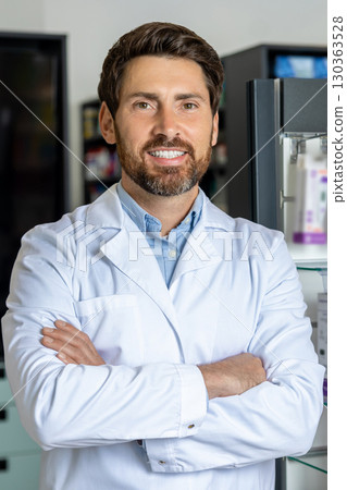 Caucasian male pharmacist in a lab coat at his working place 130363528