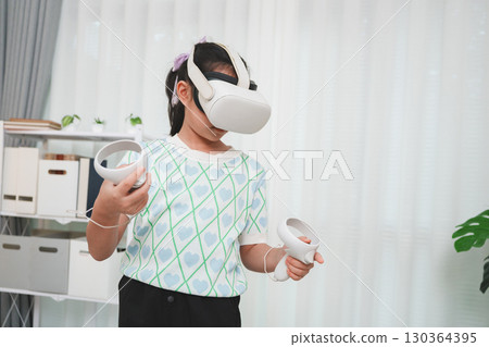 Child's interactive virtual reality experience. A kid with VR goggles playing a 3D simulation game. 130364395