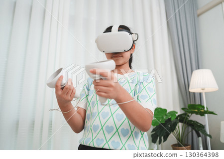 A young girl experiencing the metaverse, using a futuristic VR headset for entertainment at home. 130364398