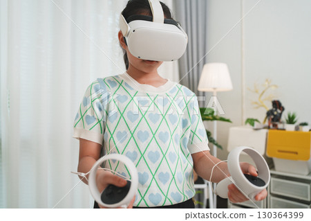 A young student uses a VR headset for interactive lesson, transforming education. This is the future of virtual learning and immersive EdTech at home. 130364399