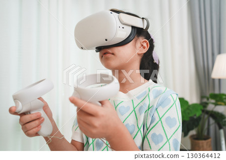 Girl Using Virtual Reality Headset for Immersive Education at Home 130364412