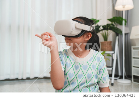 Child wearing VR headset gesturing in virtual world. Child wearing VR headset gesturing in virtual world. 130364425