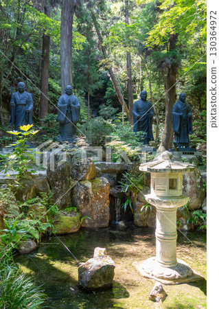 Bronze monk statues at Mitaki-Dera temple in Hiroshima, Japan 130364972