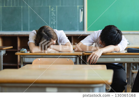 Tired high school student sleeping in the classroom 130365168