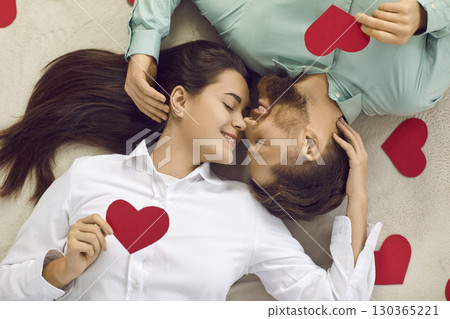 Top view of happy young couple lying on floor with closed eyes 130365221