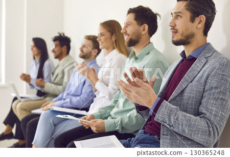 Young men and women are applauding at a business conference, lecture, or seminar 130365248