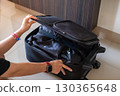 Woman hands neatly packing suitcase with clothes and travel essentials for holiday vacation trip 130365648