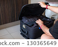 acking luggage with woman hands folding clothes for journey, tourism, or business travel 130365649