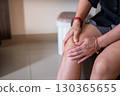 Close up of Asian woman clutching knee showing muscle strain, injury, or medical treatment 130365655